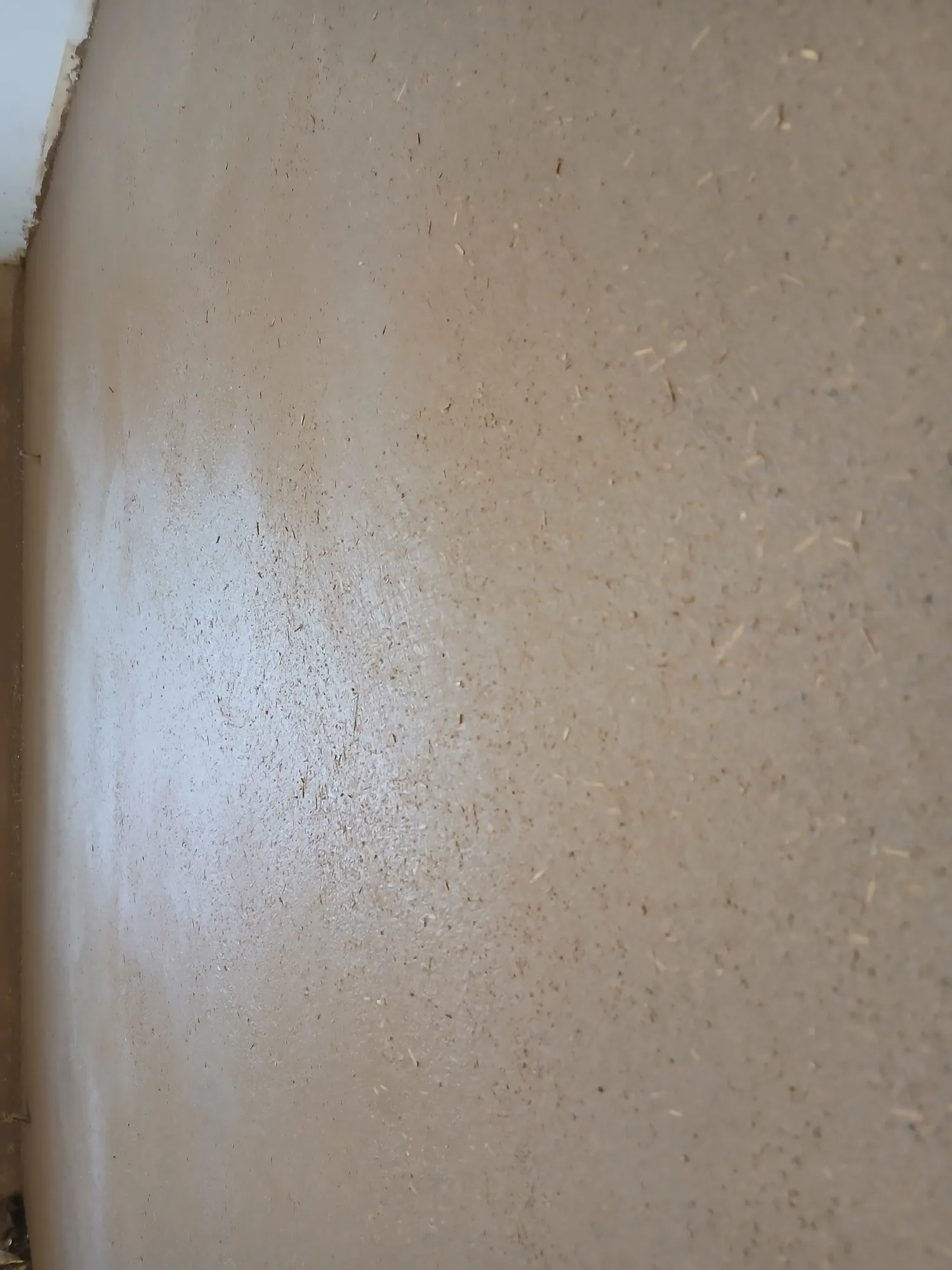 Mur intérieur en enduit d'argile lisse aux nuances beige chaud