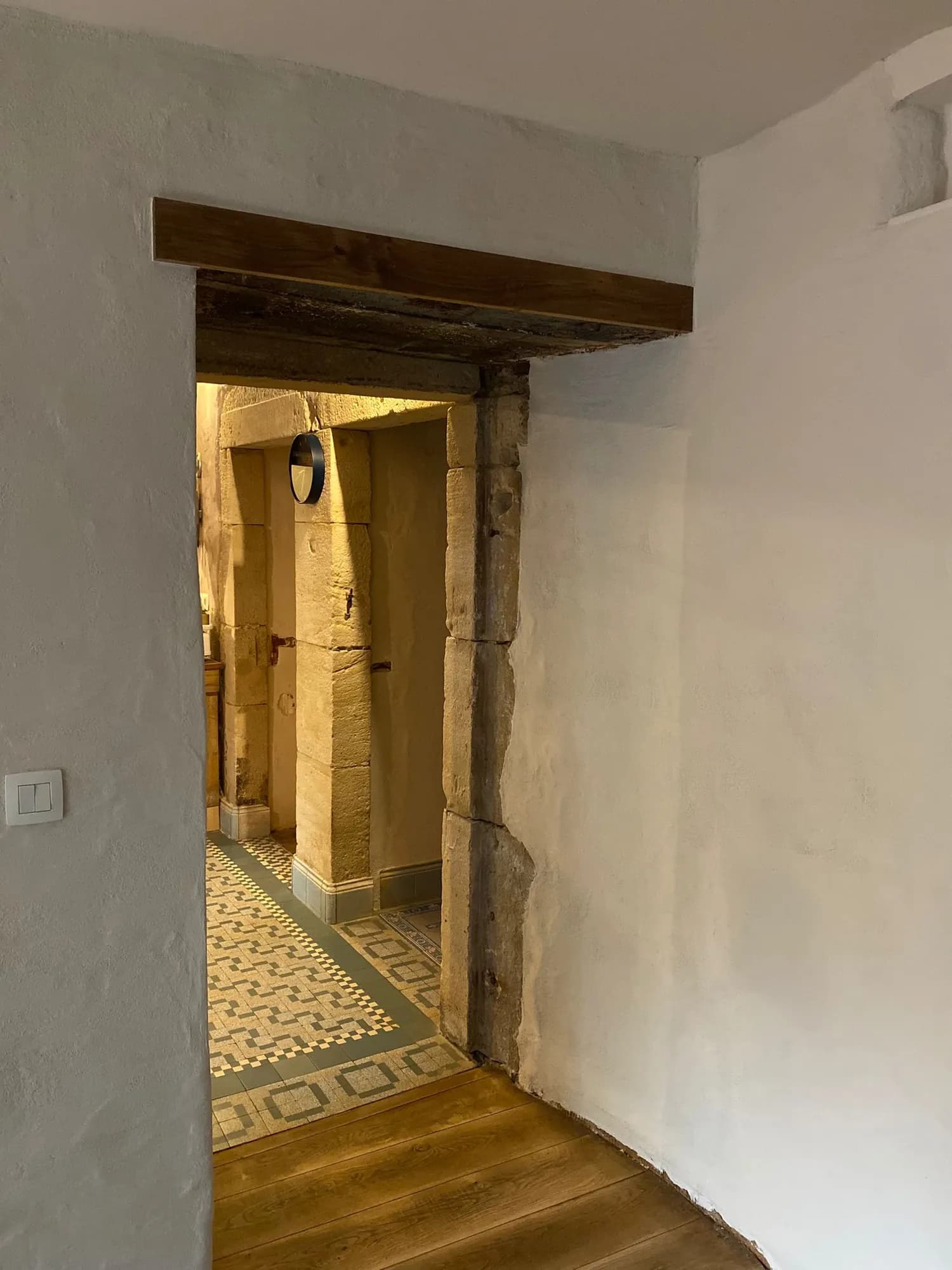 Passage voûté d'une maison ancienne enduit à la chaux, sol en carreaux de ciment