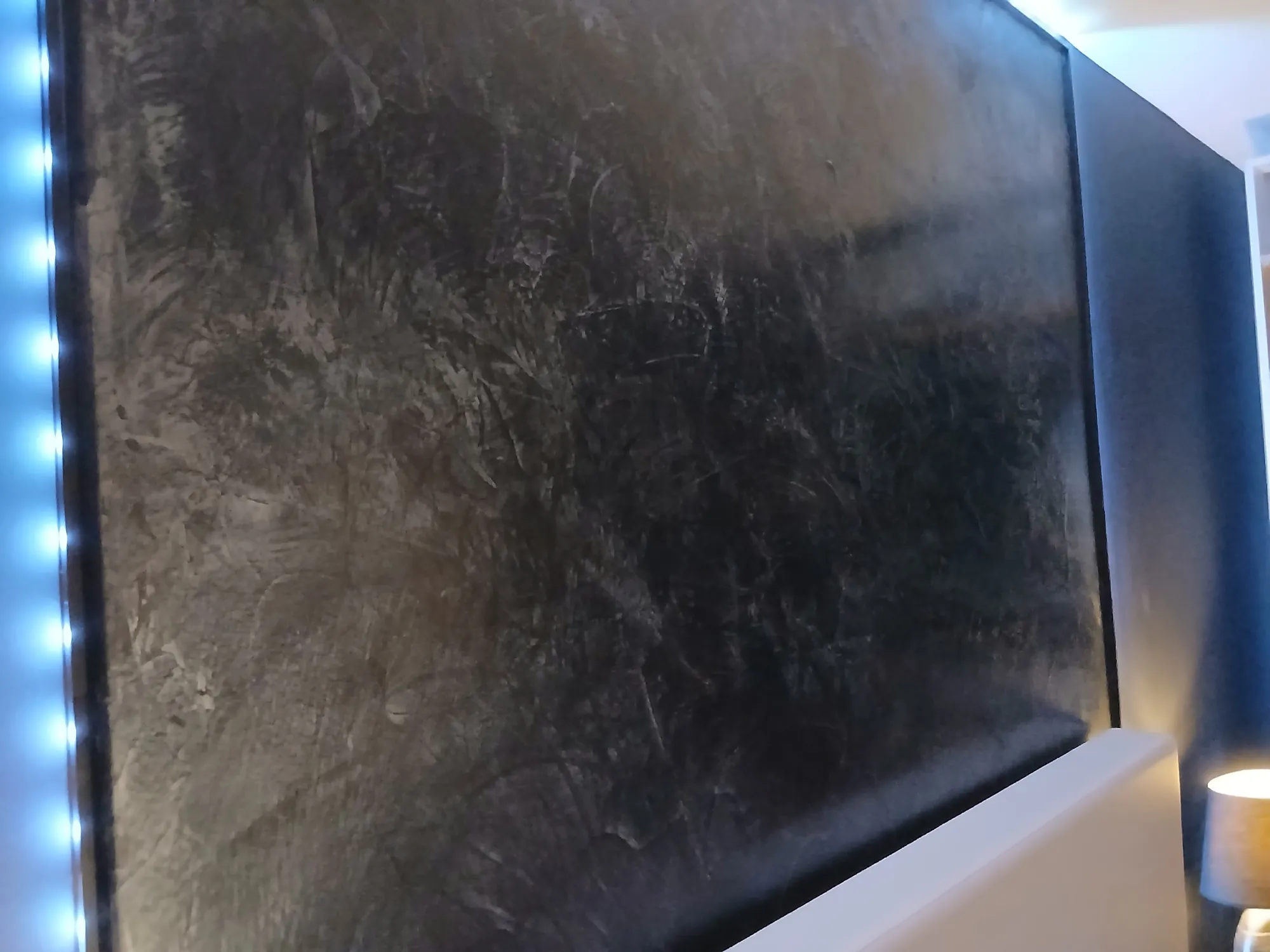 Tête de lit murale en enduit décoratif ciré effet bronze avec éclairage indirect