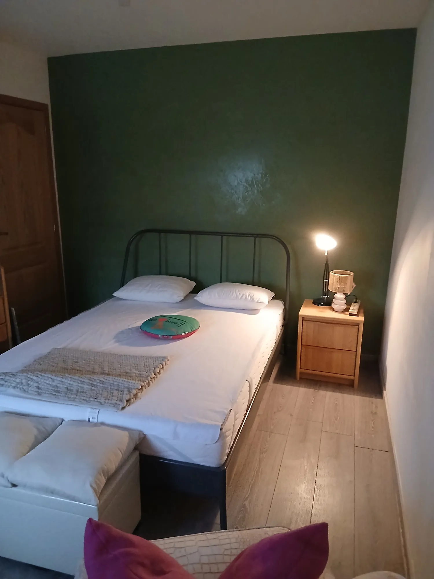 Chambre dont le mur est habillé d'un enduit décoratif vert olive mat