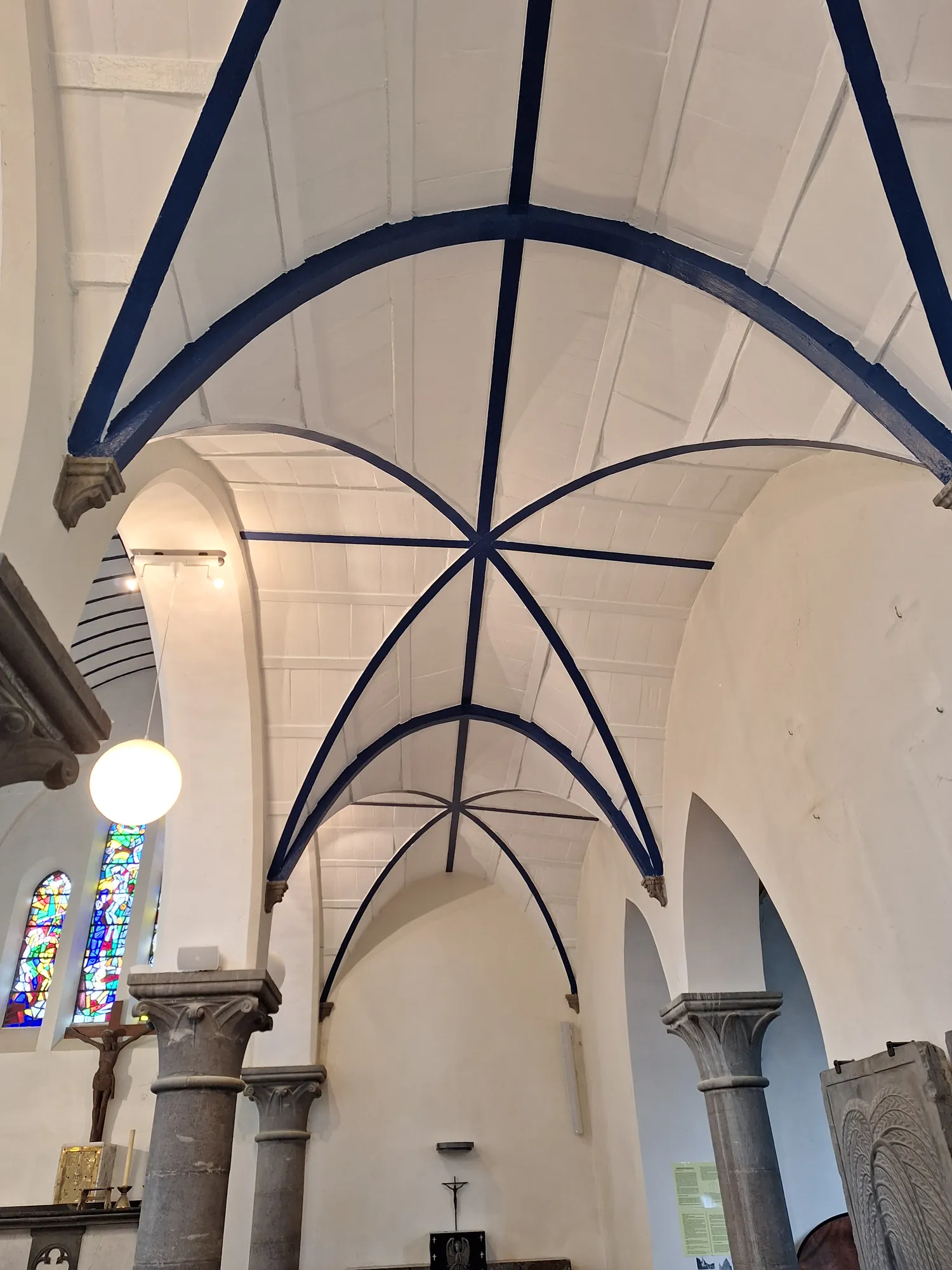 Voûtes d'église restaurées, nervures peintes en bleu profond sur fond de chaux blanche