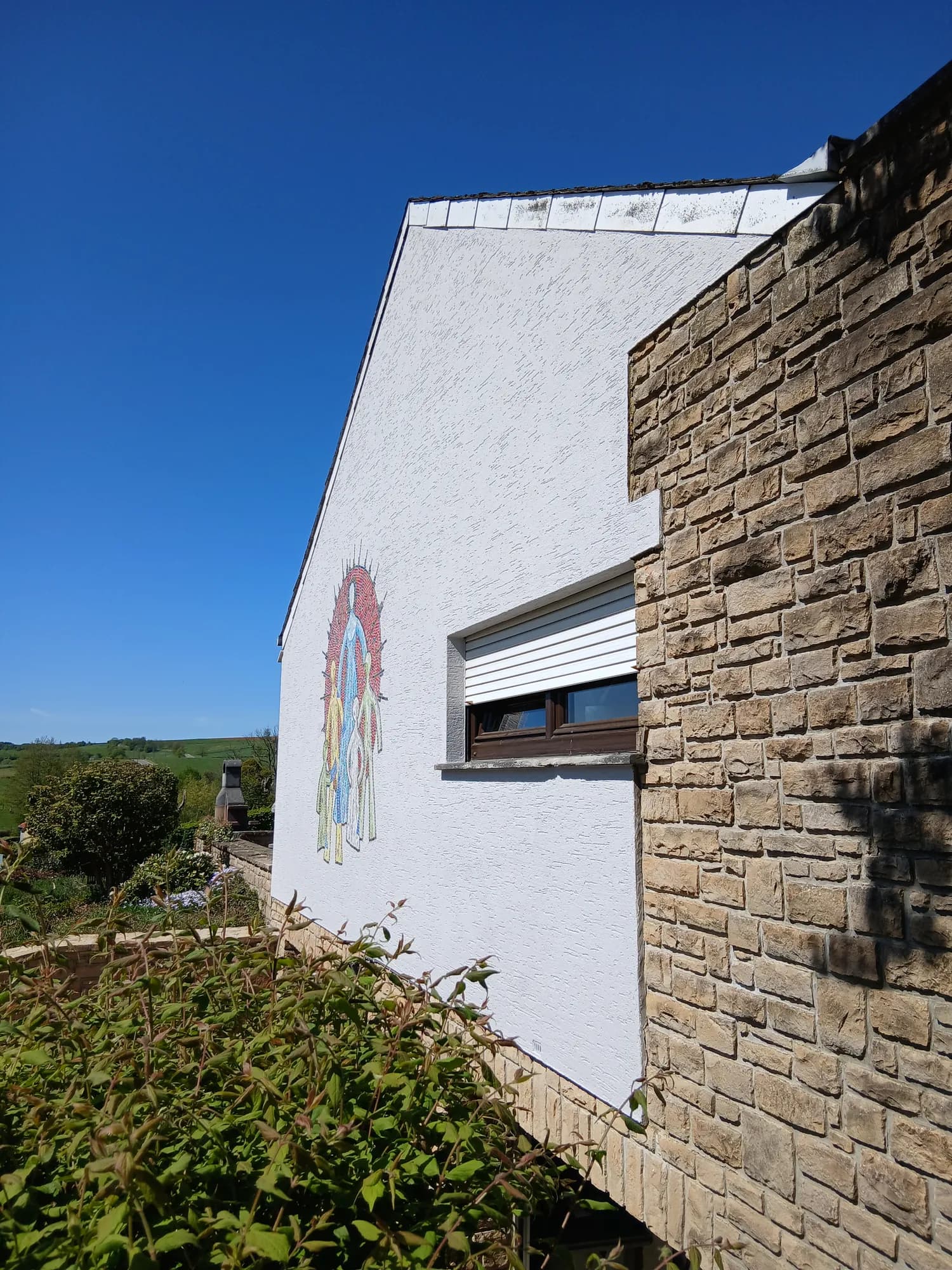Pignon de maison peint au silicate avec une fresque colorée